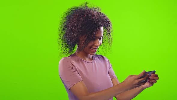 Chroma Key Shot of African Woman Plays Games Online on Smartphone