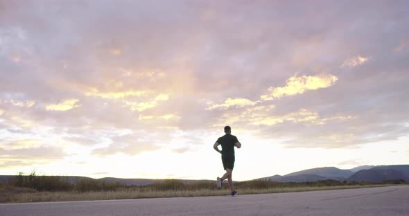 Man Jogging on Countryside Road at Sunset for Health and Wellness