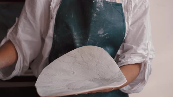 Professional Potter Decorating and Painting a Dish After She Has Baked It in the Kiln