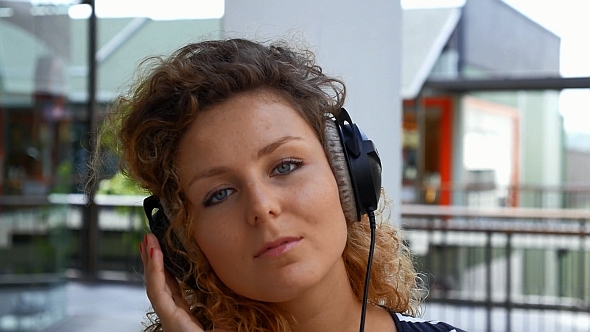 Girl Listening Music in Headphones Outdoors