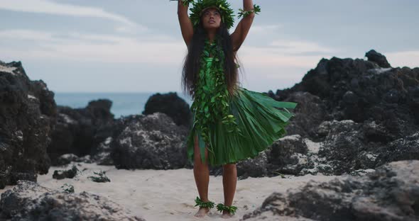 Woman performing traditional Hawaiian hula by the ocean alt