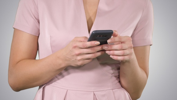 Woman hand Using a Smart Phone on gradient background.