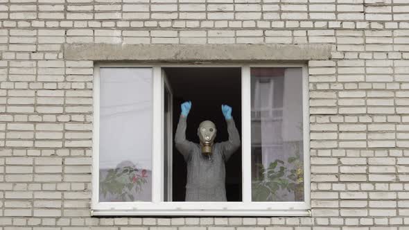 Old Man in Gas Mask Dance at Window Isolated at Home on Quarantine. Coronavirus