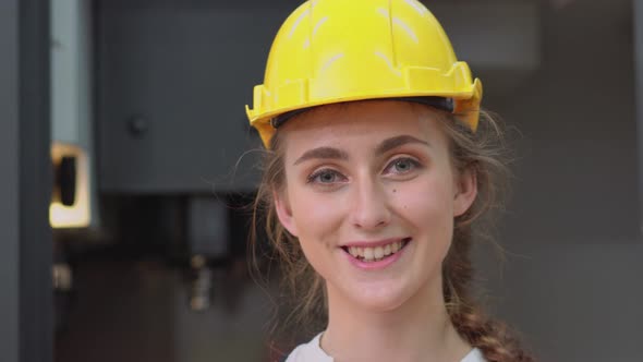 Portrait of female engineer smiling to camera at the factory