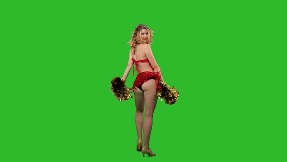 A Cheering Dance Performed By a Cheerleader in a Red Leotard with Pompoms in Her Hands in the Studio