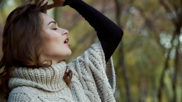 Woman relaxing in park. Happy attractive woman relaxing in sunny autumn park