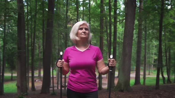 Steadicam shot of a mature caucasian woman enjoying time in forest