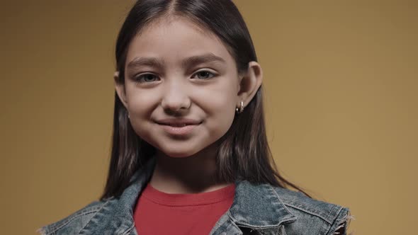 Happy Girl Turns Into Serious Smiling on a Yellow Background