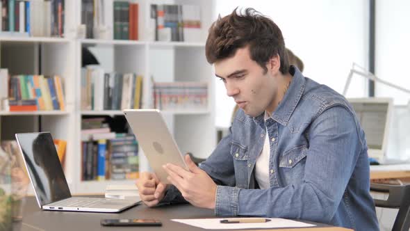 Creative Man Celebrating Success of Project on Tablet
