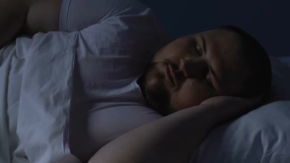 Overweight Man Sleeping in Bed at Night, Resting on Comfortable Pillow, Dreams