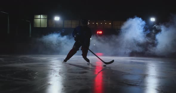 Male Hockey Player with a Puck on the Ice Arena Shows Dribbling Moving Directly Into the Camera and