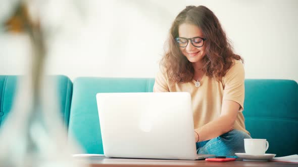 A Young Woman Remote Employee Working From Home with a Laptop