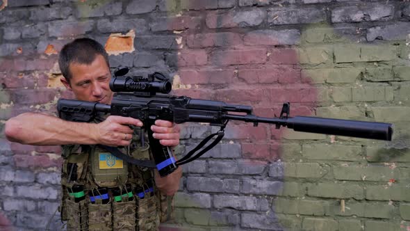 The Ukrainian Soldier Takes Aim with His Assault Rifle with Silencer