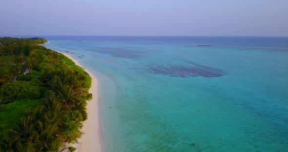 Wide birds eye clean view of a white sand paradise beach and blue sea background in high resolution 
