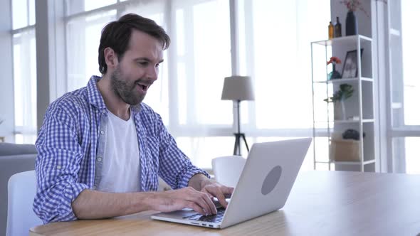 Excited Casual Beard Man Celebrating Success Working on Laptop