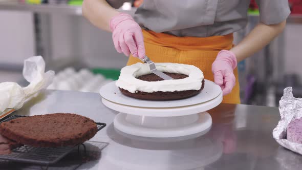 A Bright Pastry Chef Girl is Engaged in the Preparation of a Cake