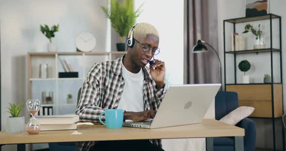 African American Man in Headphones Sitting in front of Computer During Video conference