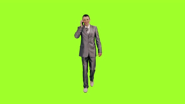 Happy Man in Suit Talking on Smartphone while Walks on Green Background