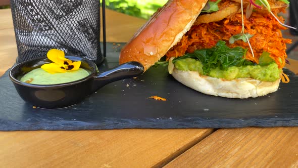 Juicy pulled chicken burger with onion rings, avocado, crispy kale, brioche bun and sweet potato fre
