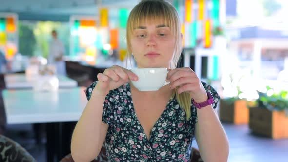 Happy Woman Drink Tea in a Cafe and Relaxing