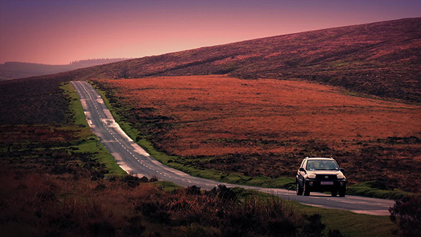 Car Drives Down Hill In Early Morning