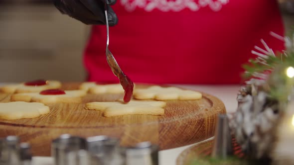 Close Up View of a Woman Hand Making a Gingerbread Cookie Using a Spoon Puts the Jam on the Cookies