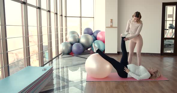 Pregnant Woman and Her Personal Trainer Doing Stretching Exercises