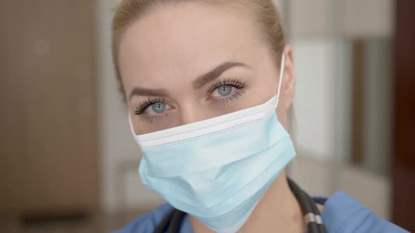 Portrait of Young Female Doctor in Medical Mask, Blue Coat and Stethoscope
