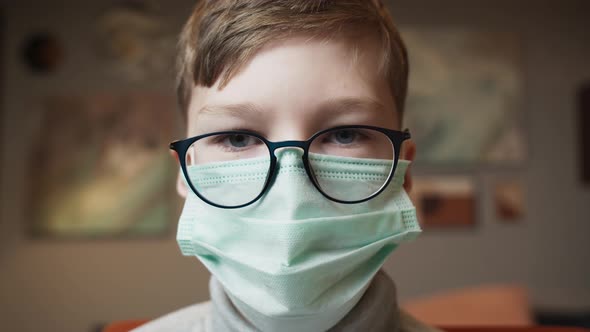 Students Return to School After COVID 19 Coronavirus Lockdown Kid Wearing a Mask Doing Homework on