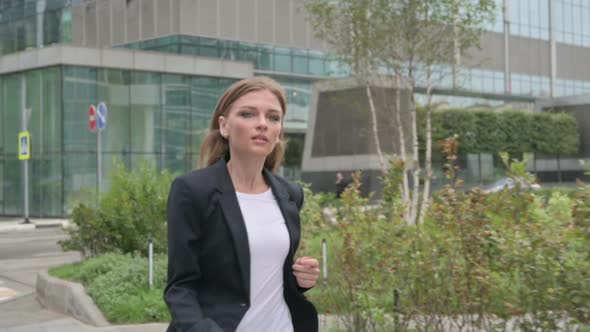 Young Businesswoman Running in Street in Slow Motion Front Pose