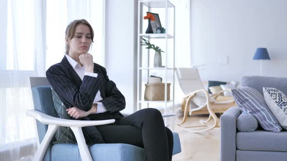 Pensive Woman Thinking while Sitting on Sofa