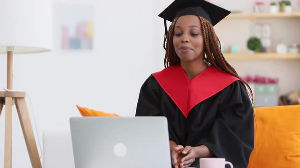 Woman Sit on Sofa in Cap and Gown and Talk to Relatives on Video Laptop Call Spbi