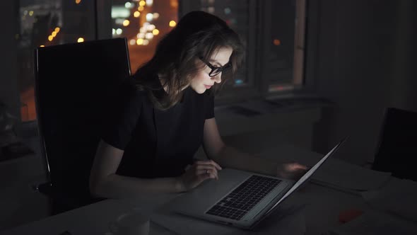 Business Woman with Glasses Working on a Computer in the Late Evening. Portrait of a Young