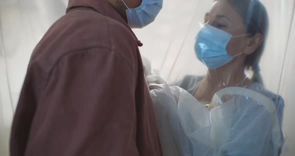 Sick Aged Woman with Coronavirus Hugging Adult Son Through Protective Plastic Curtain in Hospital