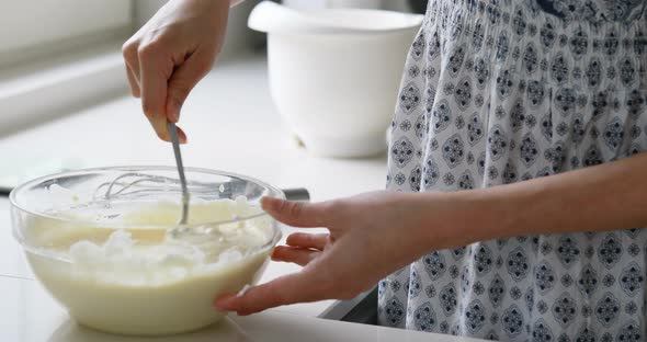 slender woman cooking in a white kitchen