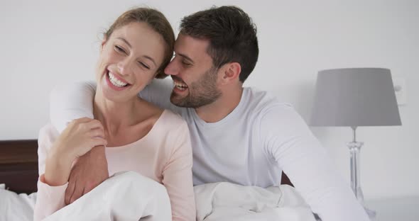 Couple sitting on bed in bedroom at comfortable home 4k