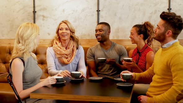 Group of happy friends interacting while having coffee 4K 4k