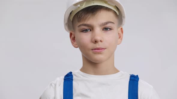 Satisfied Tired Little Builder Hanging Uniform on Shoulder Exhaling Looking at Camera Closeup