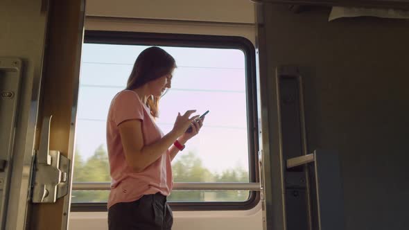 Woman Using Phone in Moving Train