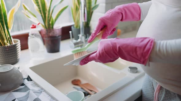 Pregnant woman washing dishes