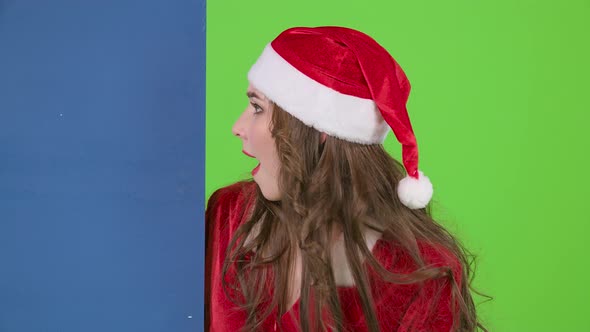 Snow Maiden Peeps Showing a Finger on a Blue Board Advertising Billboard. Green Screen. Slow Motion