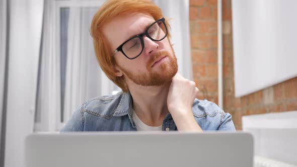 Tired Redhead Beard Man Trying to Relax, while Working on Laptop