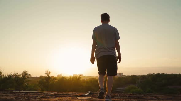 Happy man walks to the edge of the roof and raises his hands to the sides. Motivational video