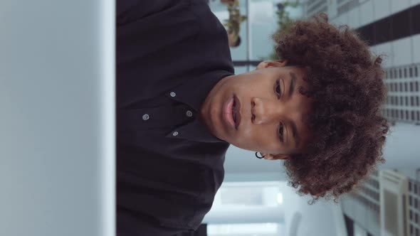 Vertical Screen African American Employee Working on Laptop in Office