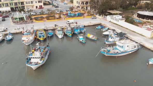 Aerial Push In Shot of Bobbing Fishing Boats In Marsaxlokk Malta