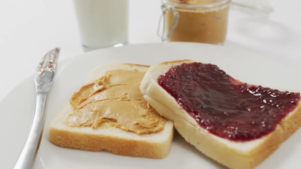 Close up view of peanut butter and jelly sandwich in a plate with copy space on white surface