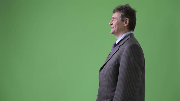 Mature Handsome Businessman Against Green Background