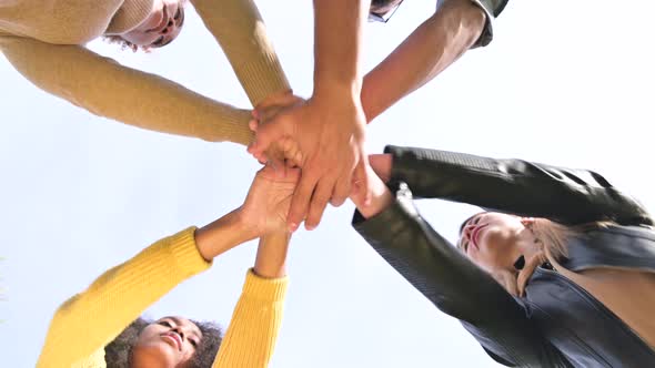 Friends and colleagues from different cultures put their hands together