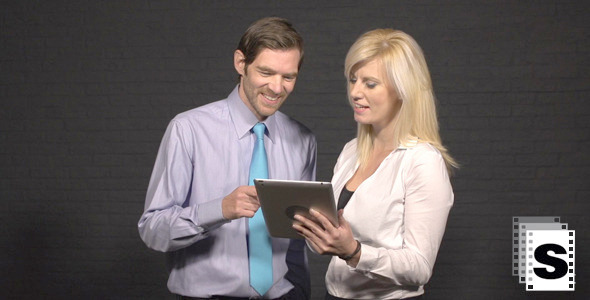 Business Couple Looking At Tablet