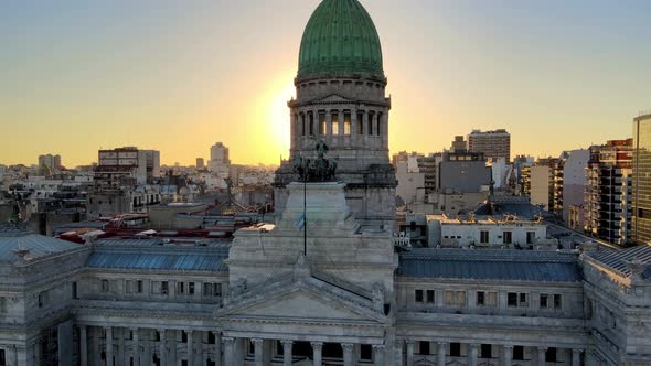 Aerial dolly out of Argentine Congress Palace with green bronze dome at golden hour with Buenos Aire